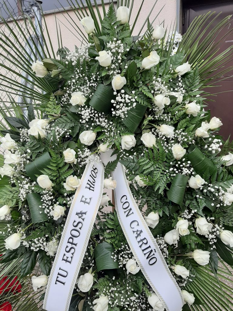 Corona funeraria hera, es una composicion de tres docenas de rosas blancas , hoja de aspidistra, helecho y palmito